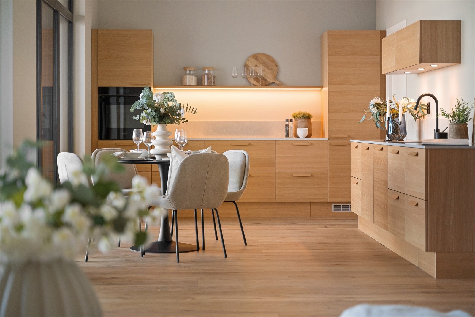 Delikat og romslig kjøkken med rikelig lysinnslipp, perfekt for matlaging og sosiale sammenkomster. Stilrent design med varme tretoner. Galleribilde