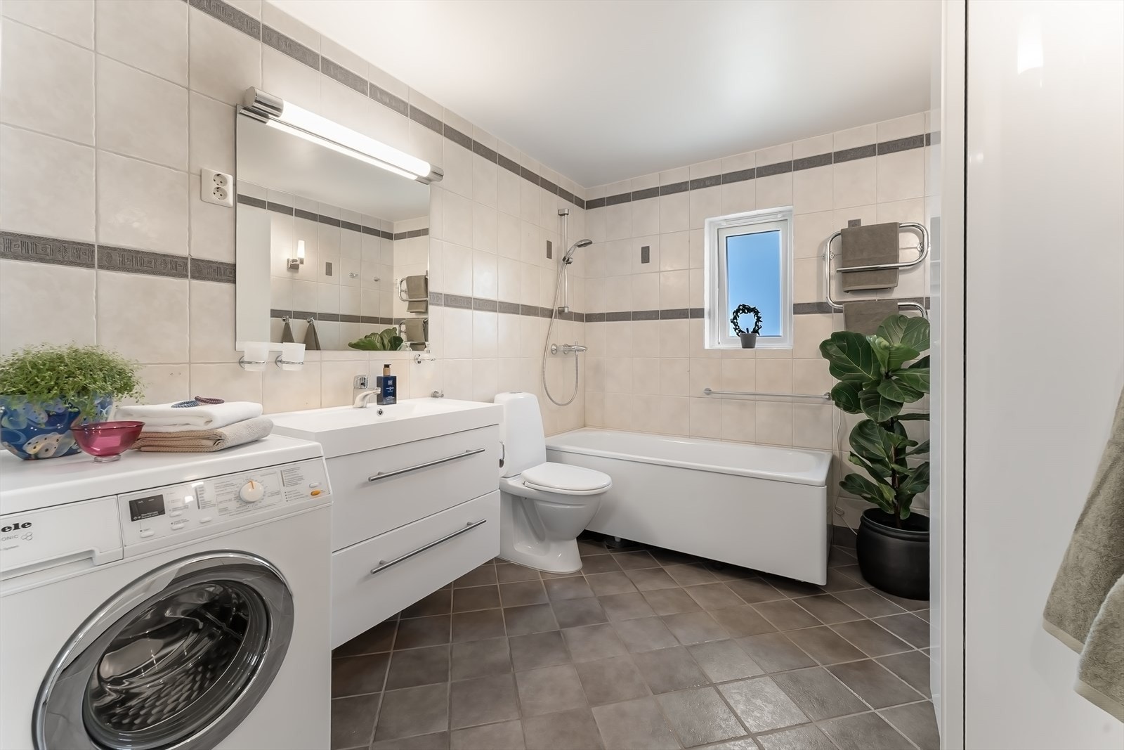 Leiligheten har 2 baderom.
Her fra det romslige hovedbadet som er innredet med badekar, servantskap og toalett. Badet har opplegg for vaskemaskin Galleribilde