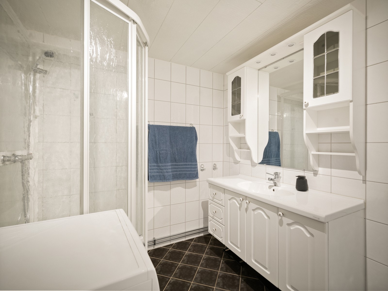 Badet er innredet med servantinnredning, et gulvmontert toalett og dusjkabinett, samt at det er opplegg for vaskemaskin. Galleribilde