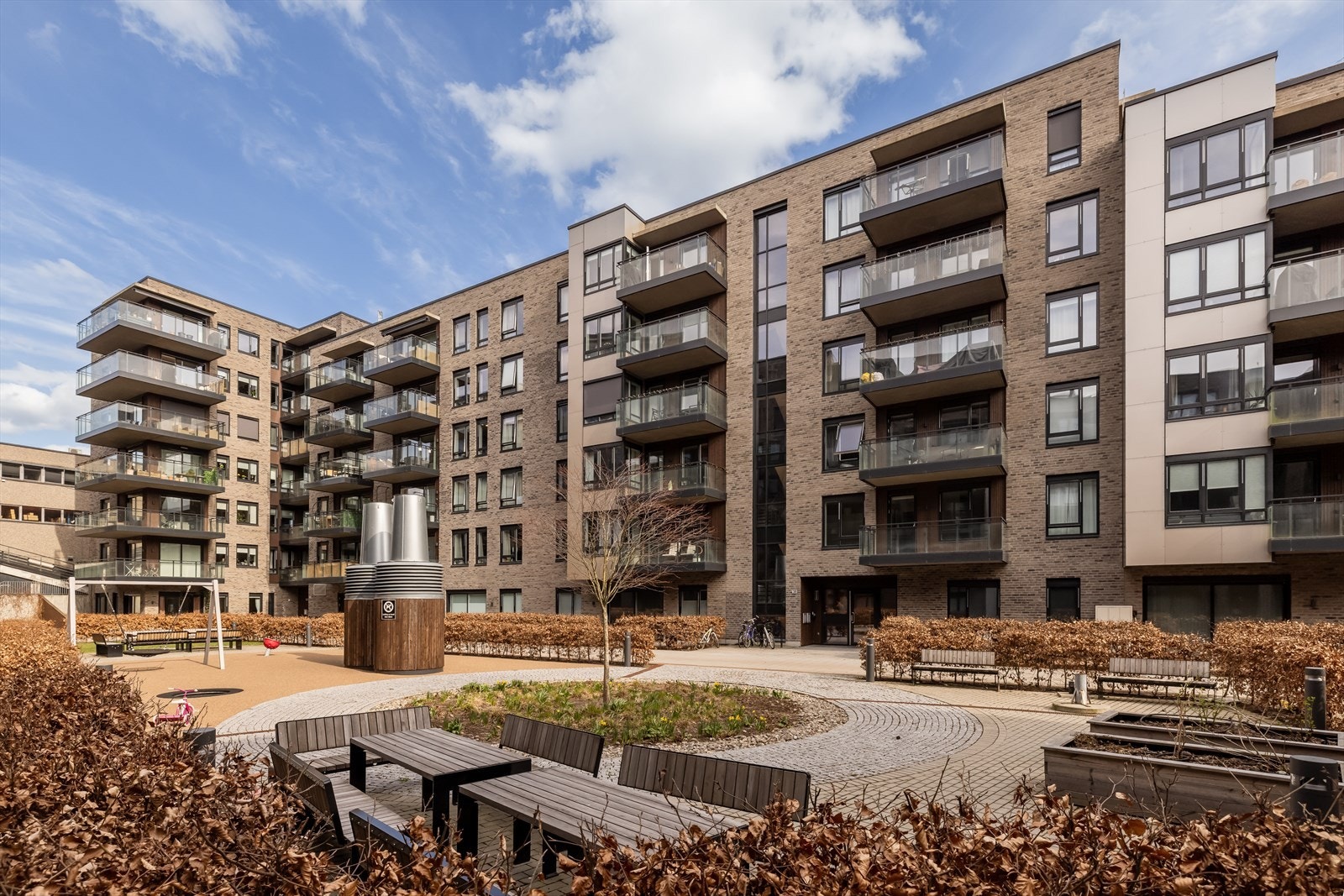 Moderne leilighetsbygg fra 2021 med heisadkomst. Fasaden er kledd med teglstein og trepanel. Galleribilde