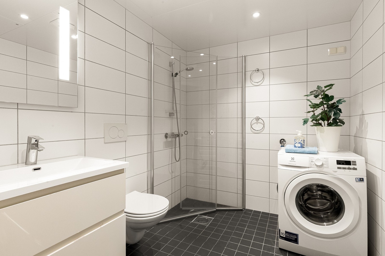 Boligen har et stort og pent bad med elektriske varmekabler, downlights og opplegg til vaskemaskin Galleribilde