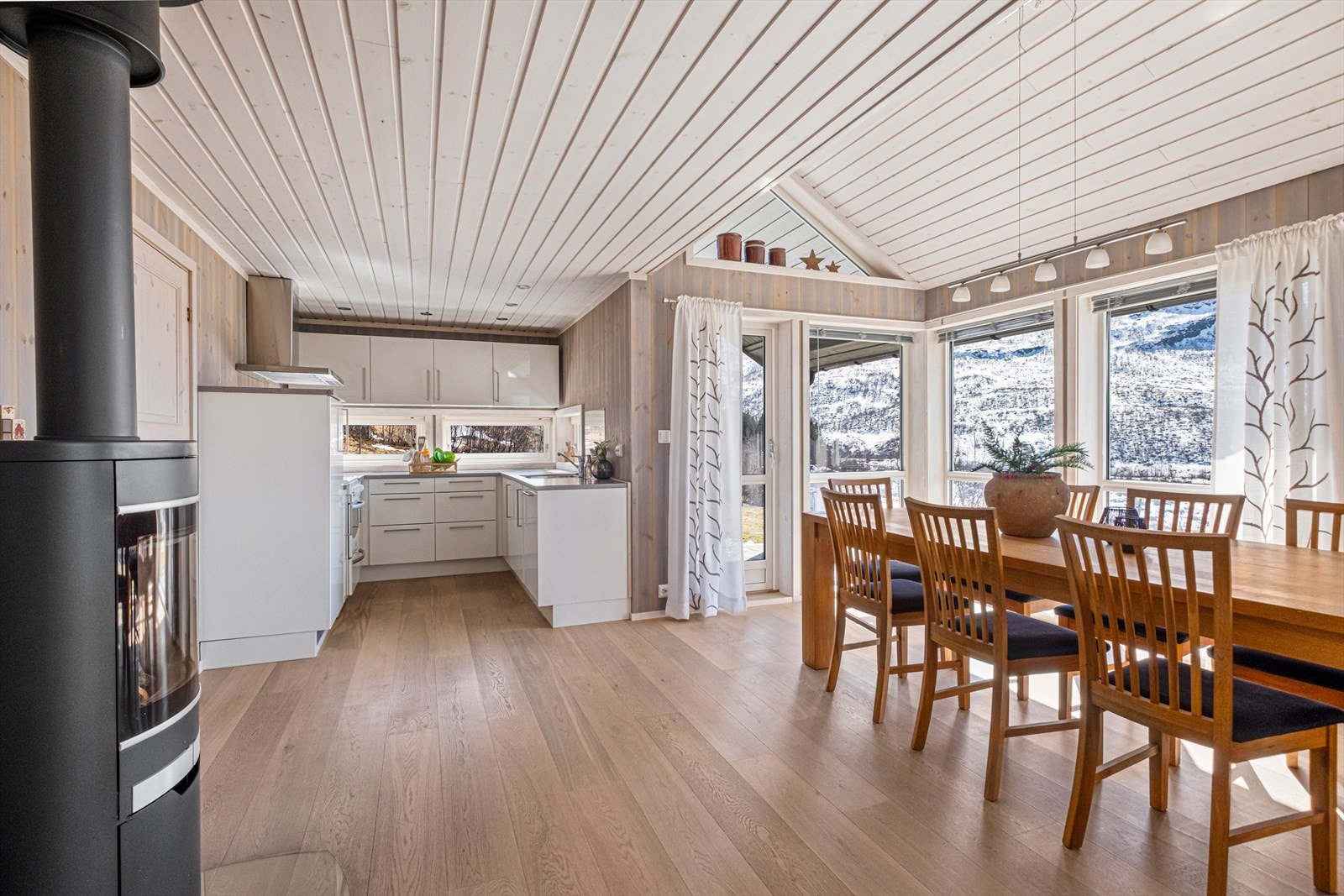 Romslig og stor stue med god takhøyde, plass til både sofa- og spisestue, samt utgang til overbygget terrasse. Galleribilde