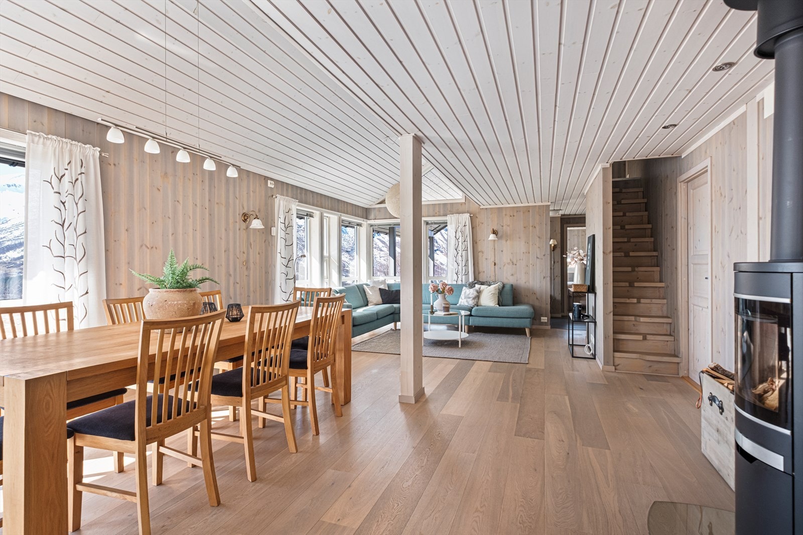 Romslig og stor stue med god takhøyde, plass til både sofa- og spisestue, samt utgang til overbygget terrasse. Galleribilde