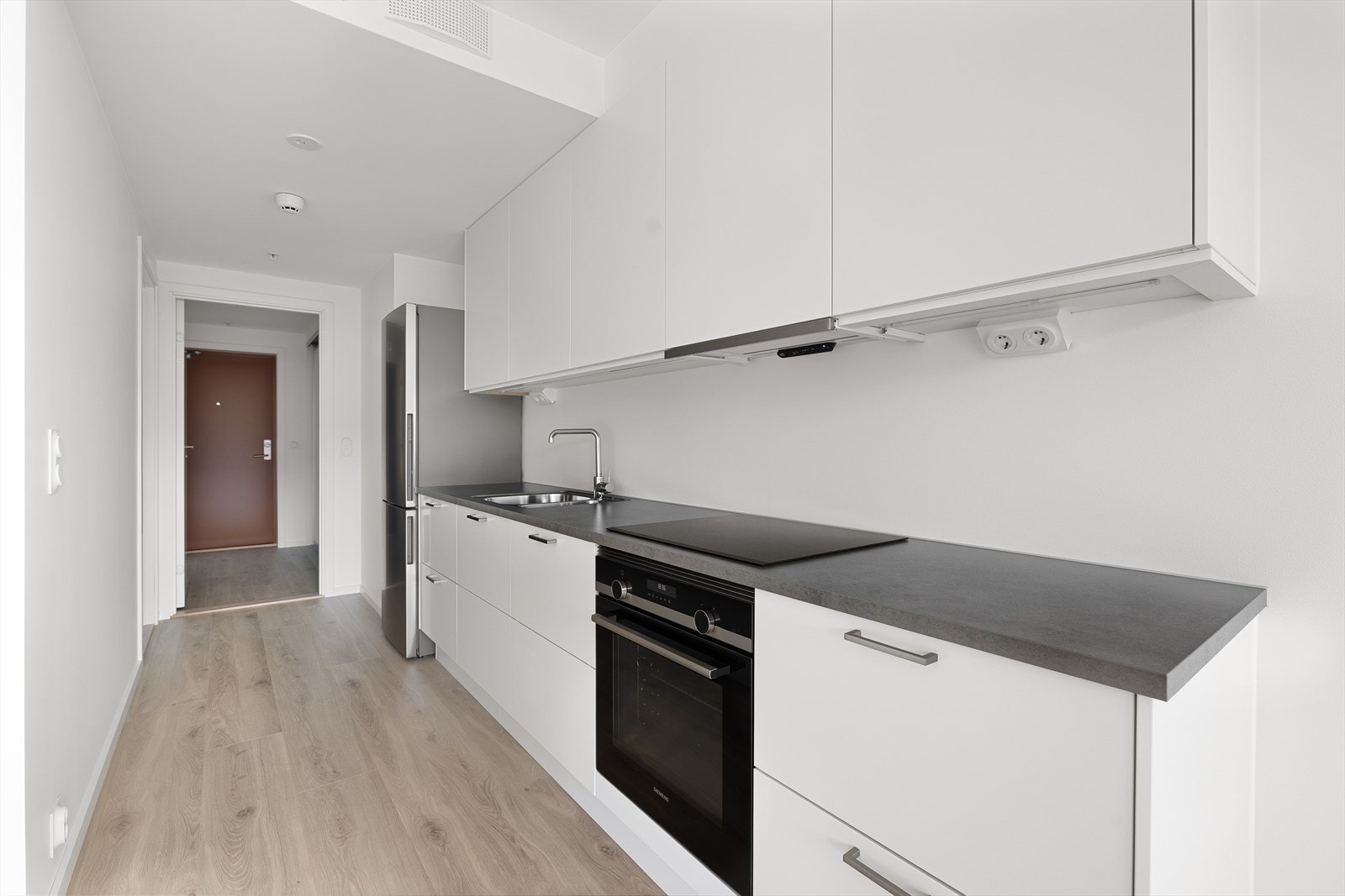 Kjøkkenet har platetopp, ventilatorhette og plass til integrerte hvitevarer. Galleribilde