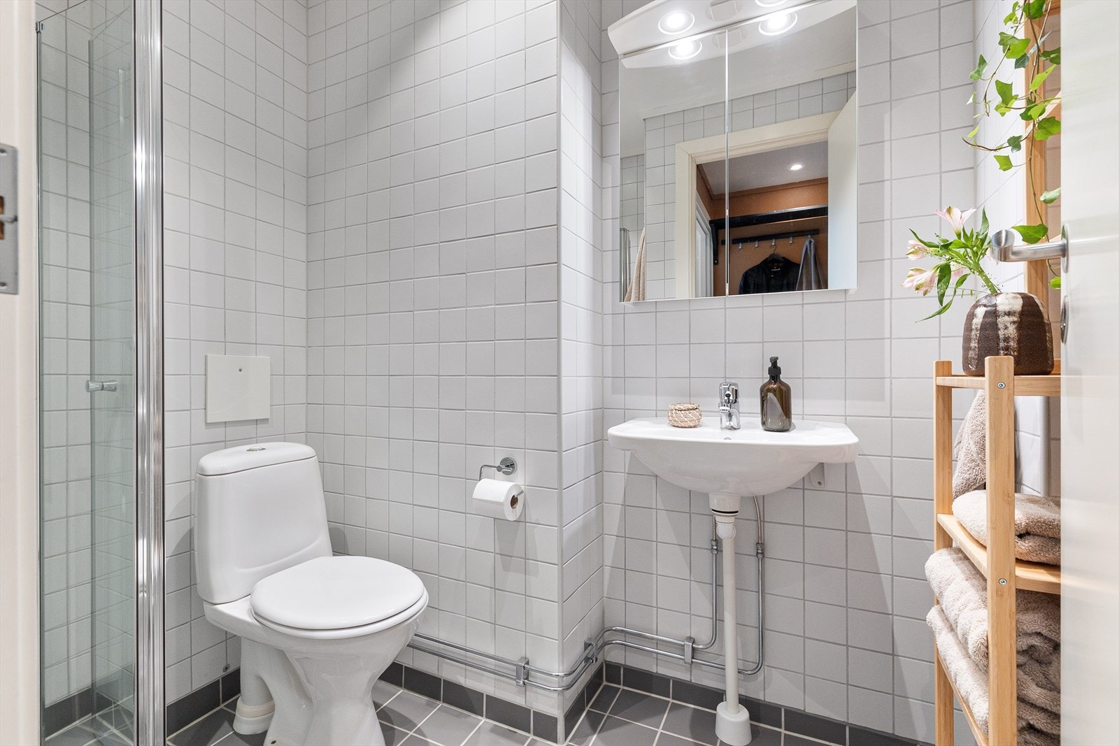 Det er flislagt gulv med behagelig gulvvarme, veggmontert WC og en dusjplass med vegger. Galleribilde
