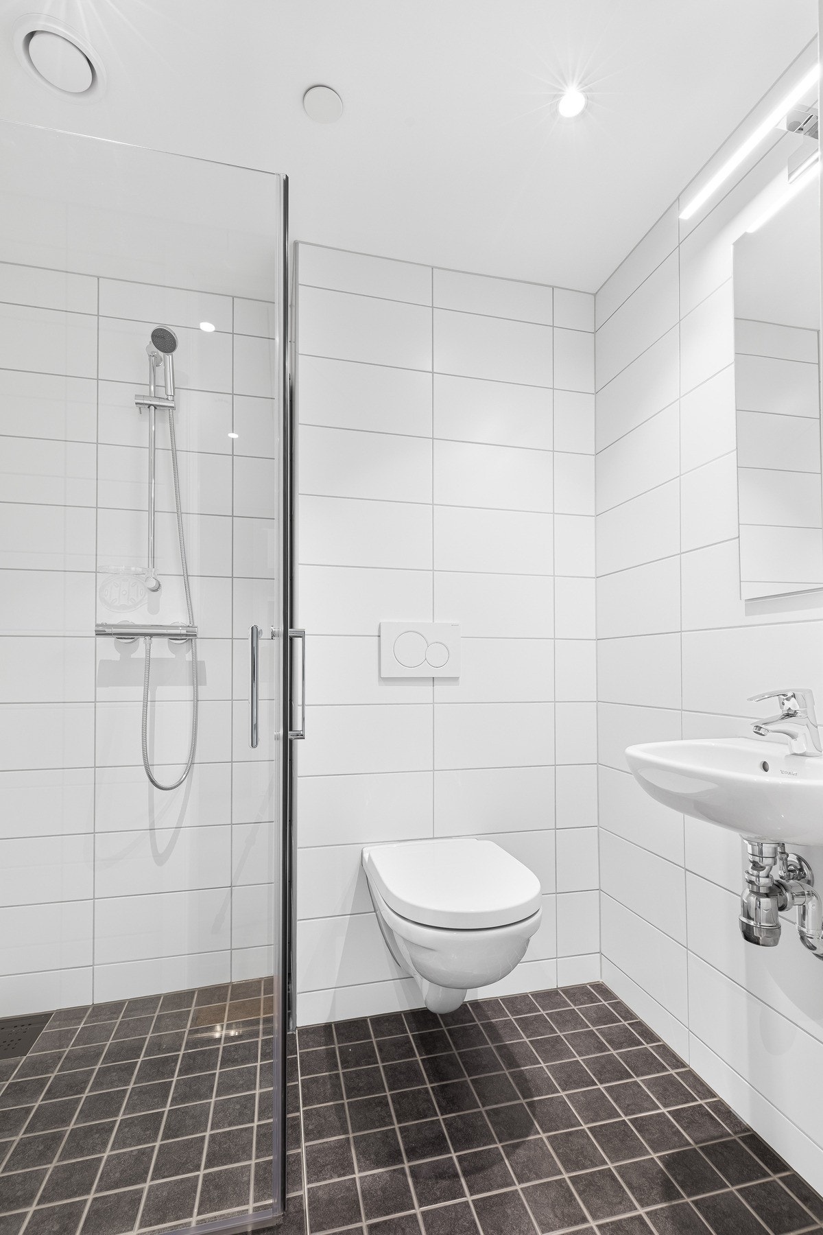 På badet tilhørende hovedsoverommet er det dusjhjørne, vegghengt toalett og speil over vasken. Galleribilde