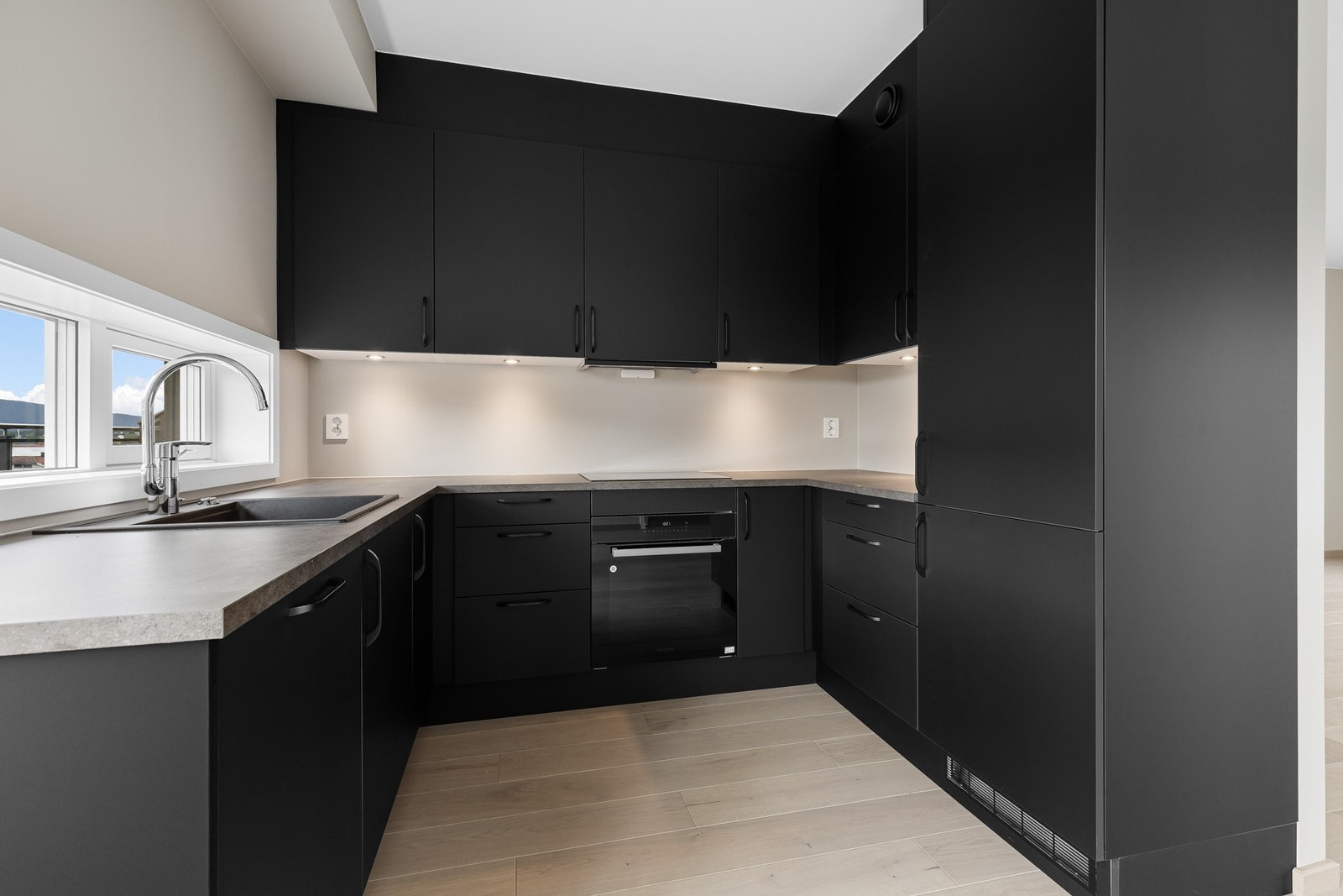 Den lekre, moderne innredningen er fra Designa, og har sorte, slette fronter som gir en fin kontrast til de lyse veggene. Galleribilde