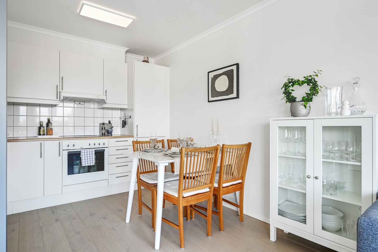Lyst og pent kjøkken med slette fronter og benkeplate i laminat. Galleribilde