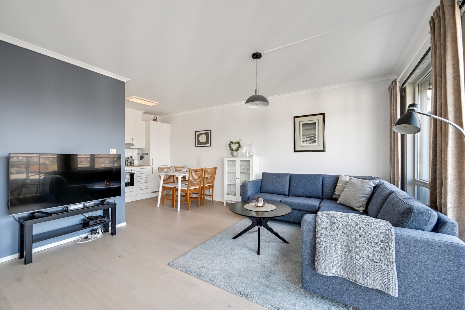 Åpen stue- og kjøkkenløsning med god plass til både sofagruppe og spisebord - en luftig og sosial sone med gjennomgående lys og moderne uttrykk. Galleribilde