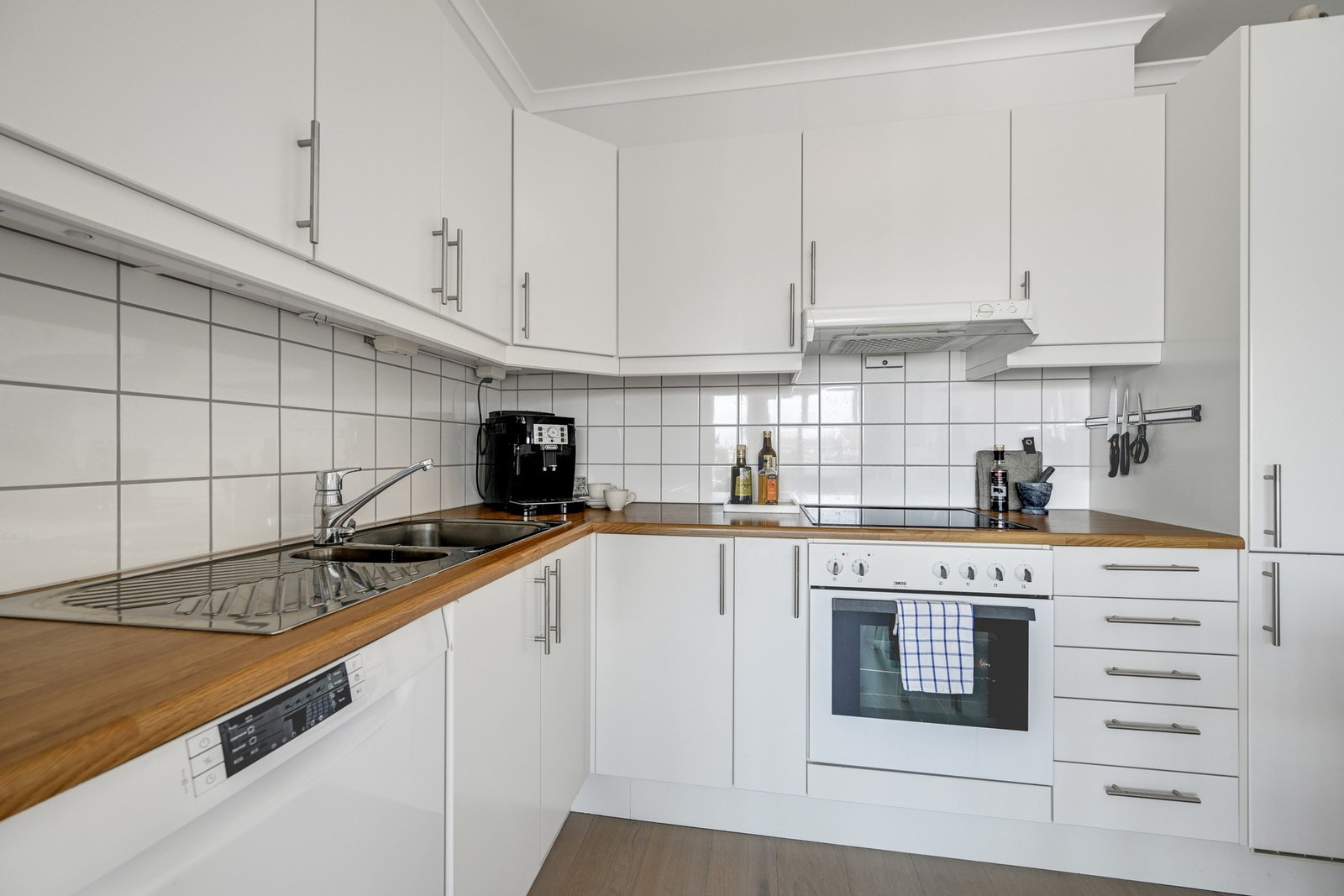 Det er kjøleskap, oppvaskmaskin, platetopp, stekeovn og komfyrvakt. Galleribilde