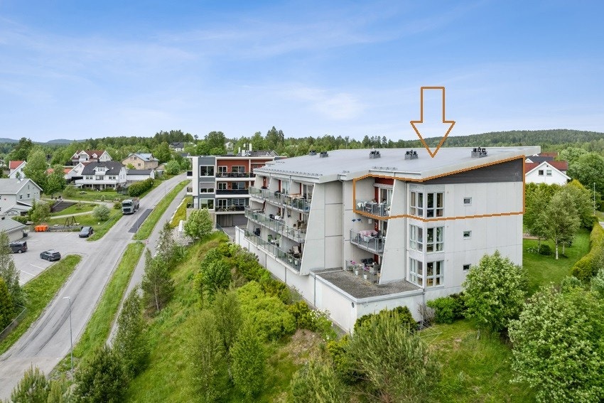 Leiligheten ligger på toppen av bygget, på enden mot syd (dronefoto) Galleribilde