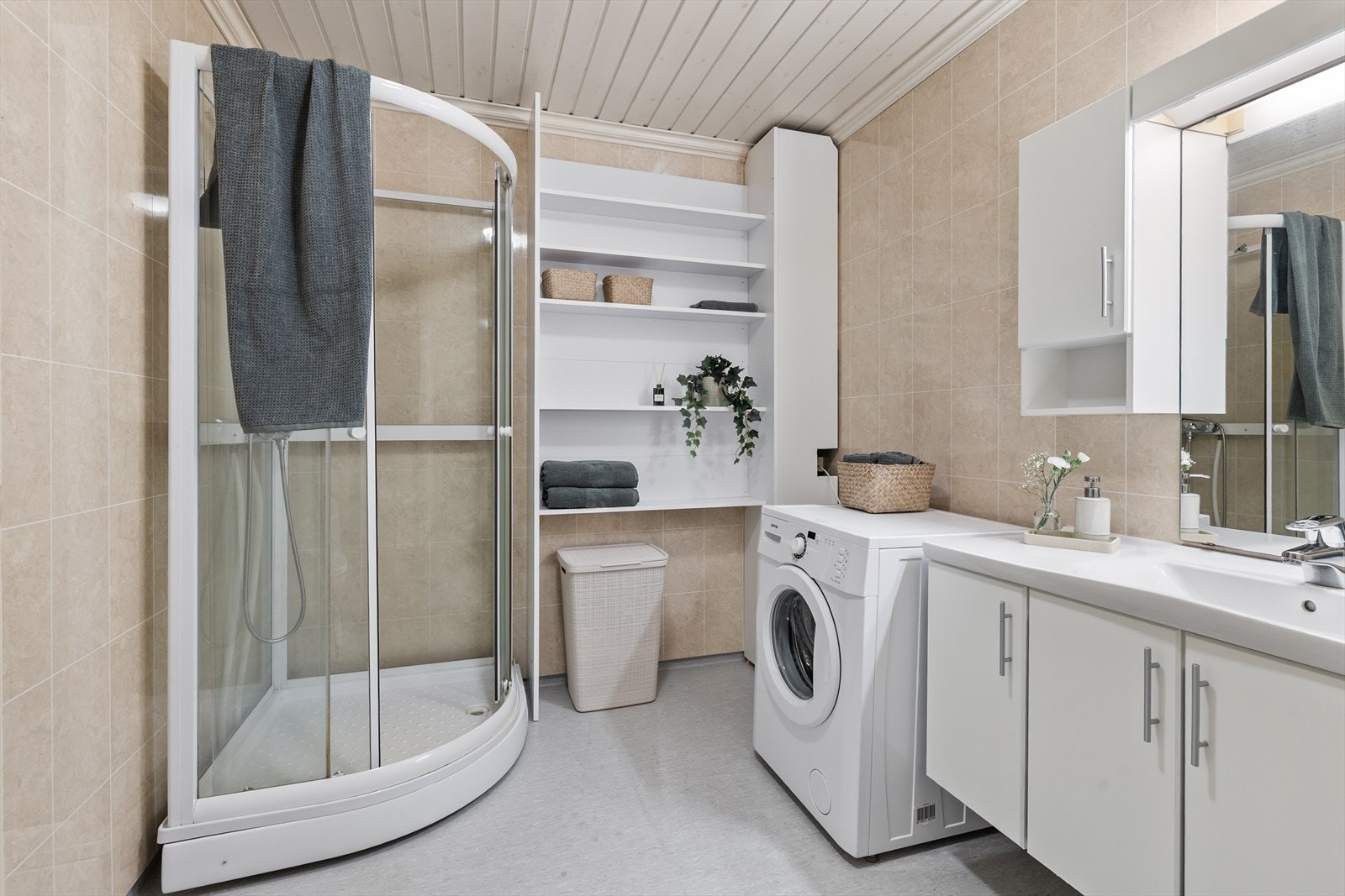 Badet/vaskerommet fremstår som praktisk og funksjonelt innredet, med gode løsninger som dekker hverdagens behov. Rommet er utstyrt med dusjkabinett, toalett og et baderomsmøbel med servant som gir både oppbevaringsplass og en ryddig helhet. Galleribilde