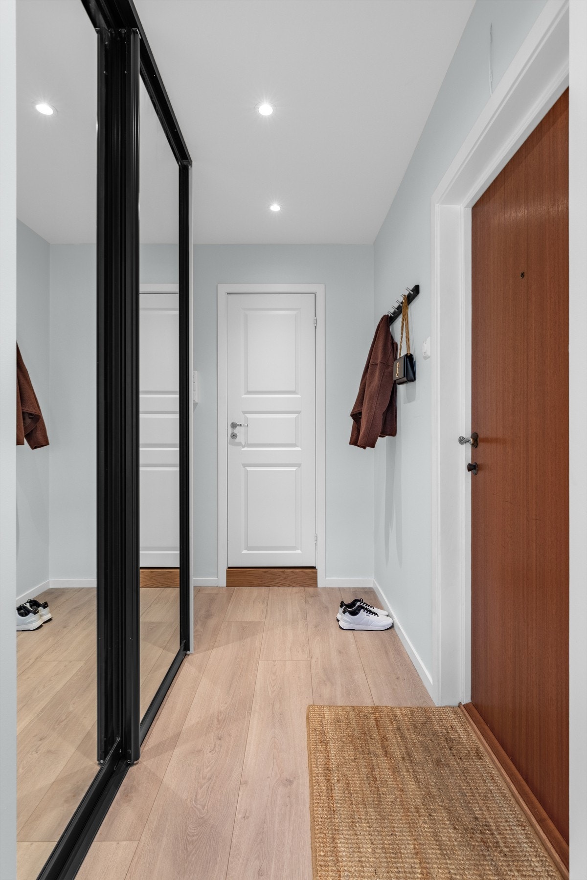 Speisialbestilt skyvedørsgarderobe i sort med glassfronter er montert og medfølger Galleribilde