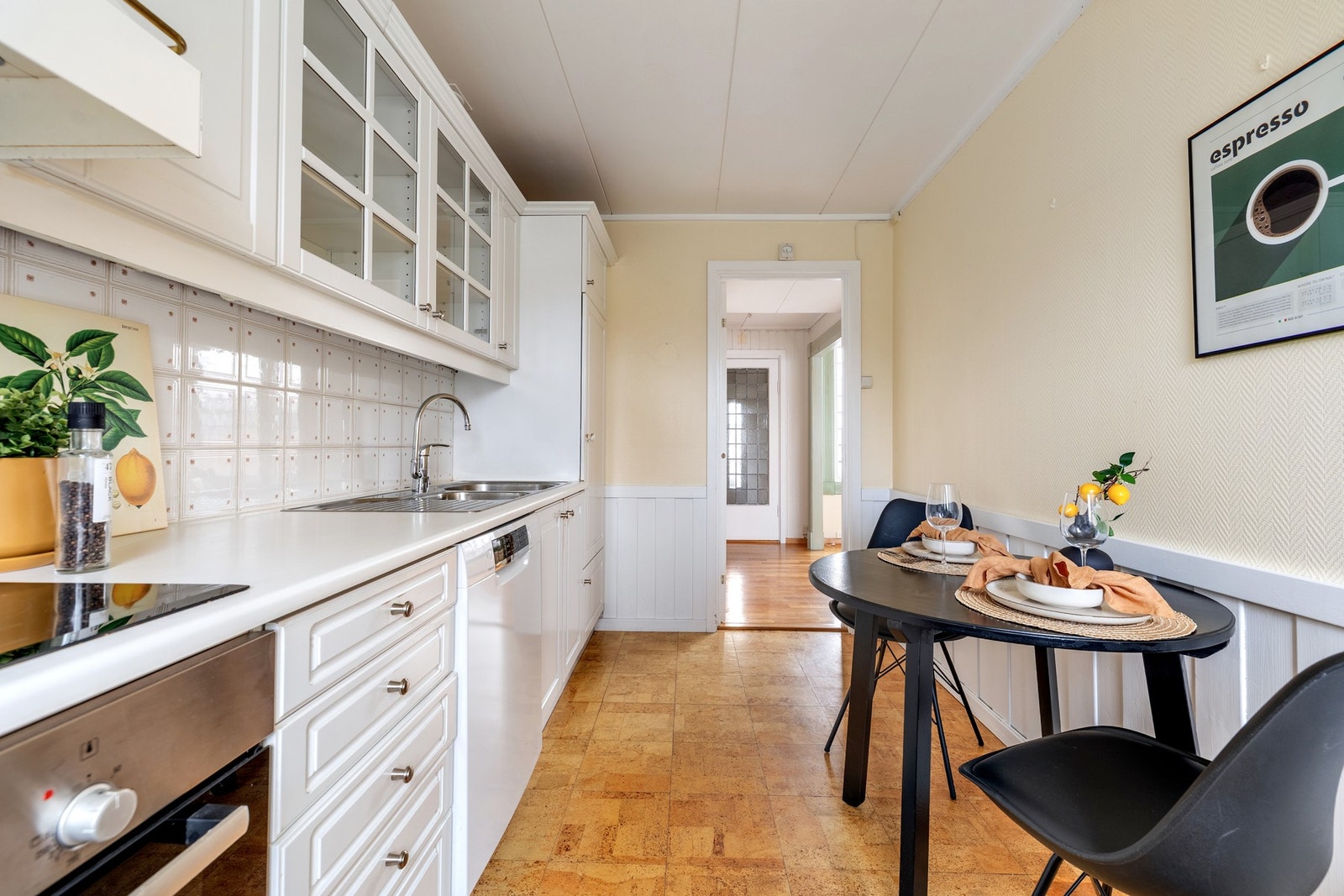 Kjøkkeninnredningen har lysmalte profilerte fronter og laminerte benkeplater med nedfelt oppvaskkum med avrenningsplate. Galleribilde