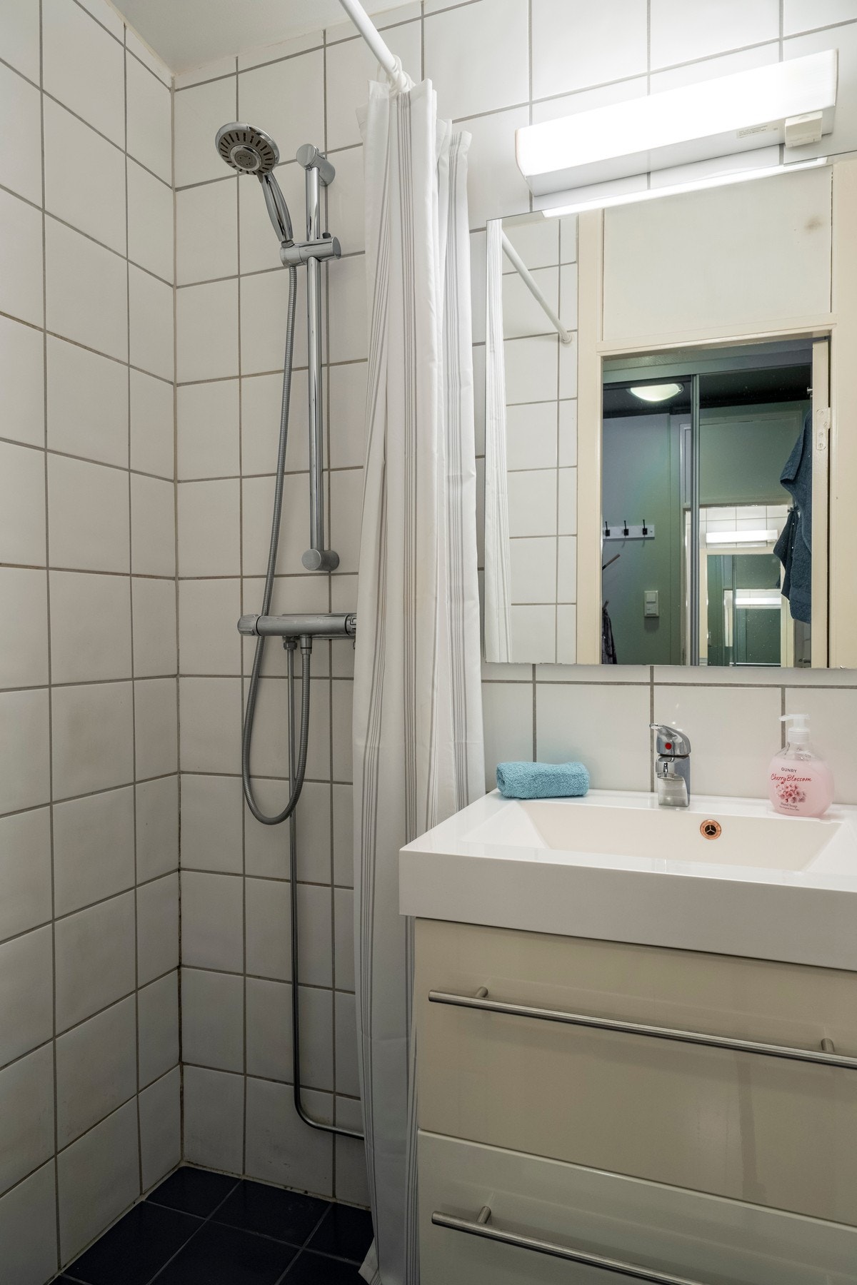 Badet har gulvvarme og speil med overlys og stikkontakt over servant. Galleribilde