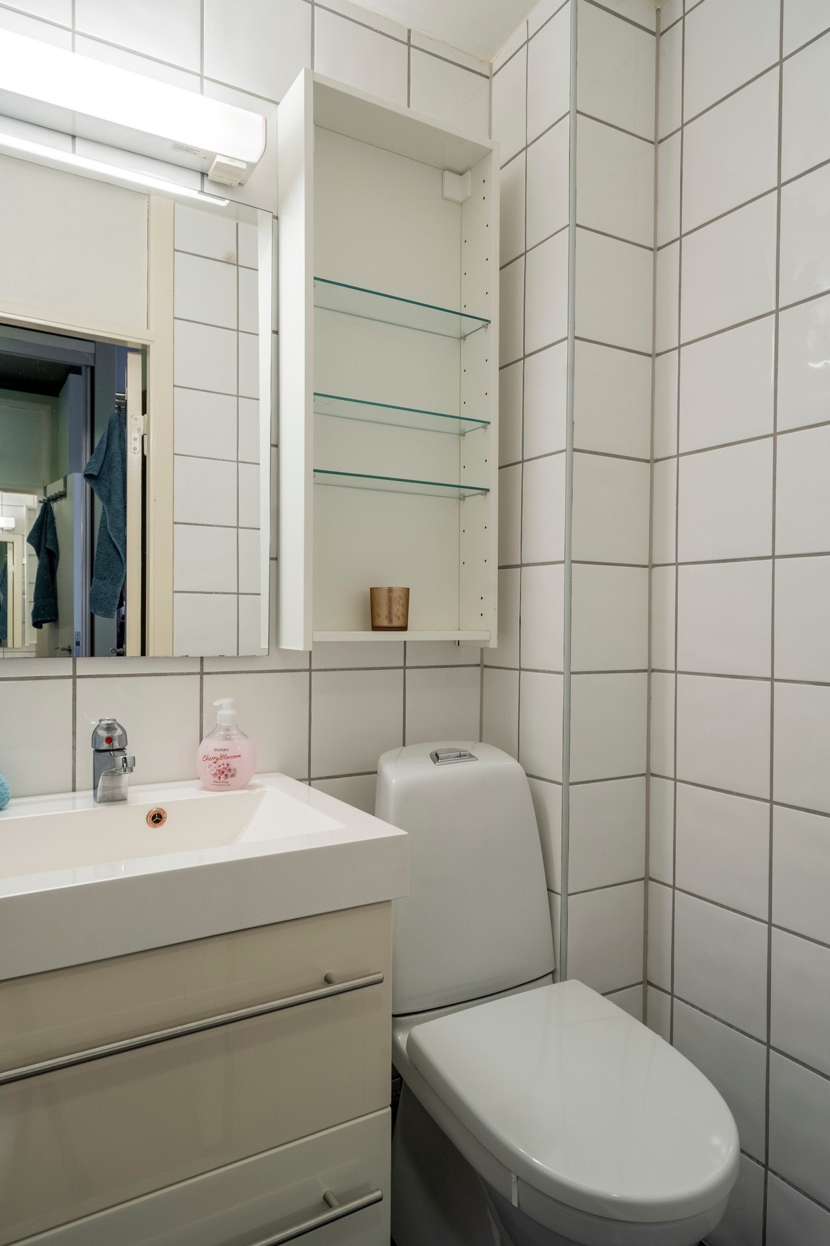 Badet har fliser på gulv og vegger og toalett fra 2018. Galleribilde