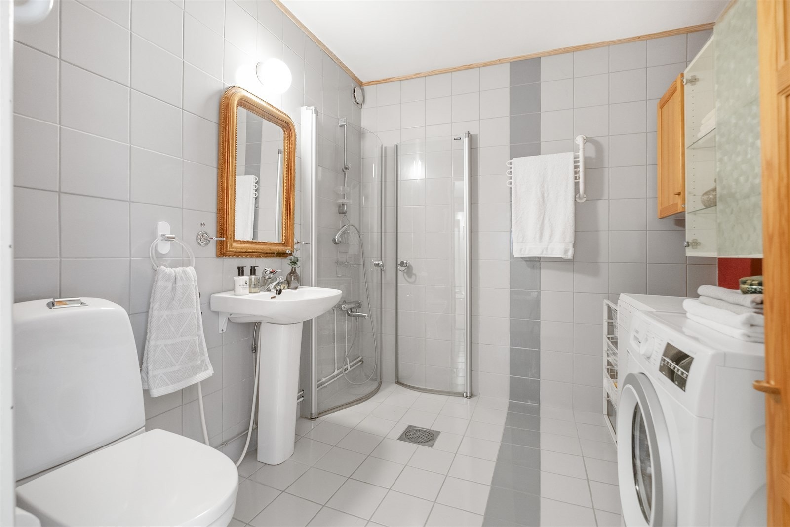Badet har flislagte overflater med opplegg for vaskemaskin. Galleribilde