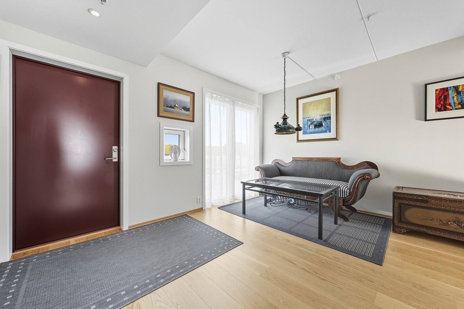 Inngangsparti vist med rommet møblert med sofa Galleribilde