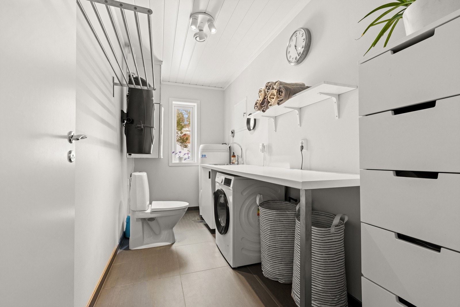 Vaskerom med flislagt gulv og separat wc Galleribilde