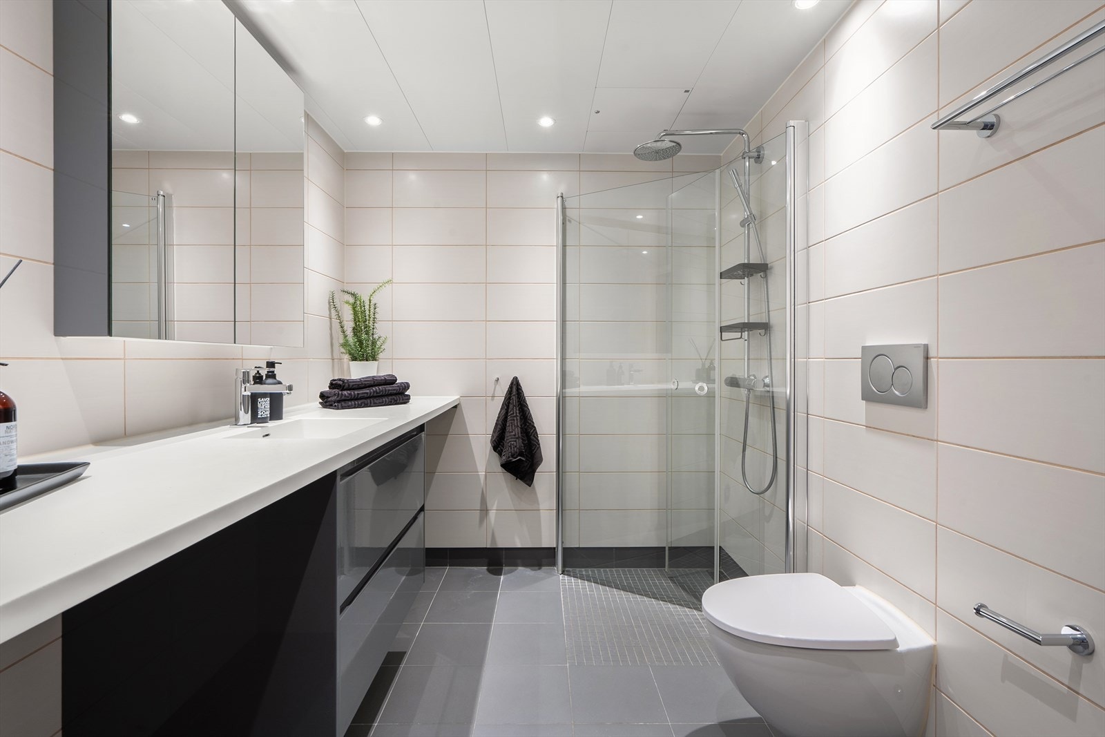 Badet tilknyttet hovedsoverommet er innredet med dusjhjørne med to rette glassfronter i herdet glass. Dusjen har både regnfallsdusj og håndholdt dusj. Galleribilde