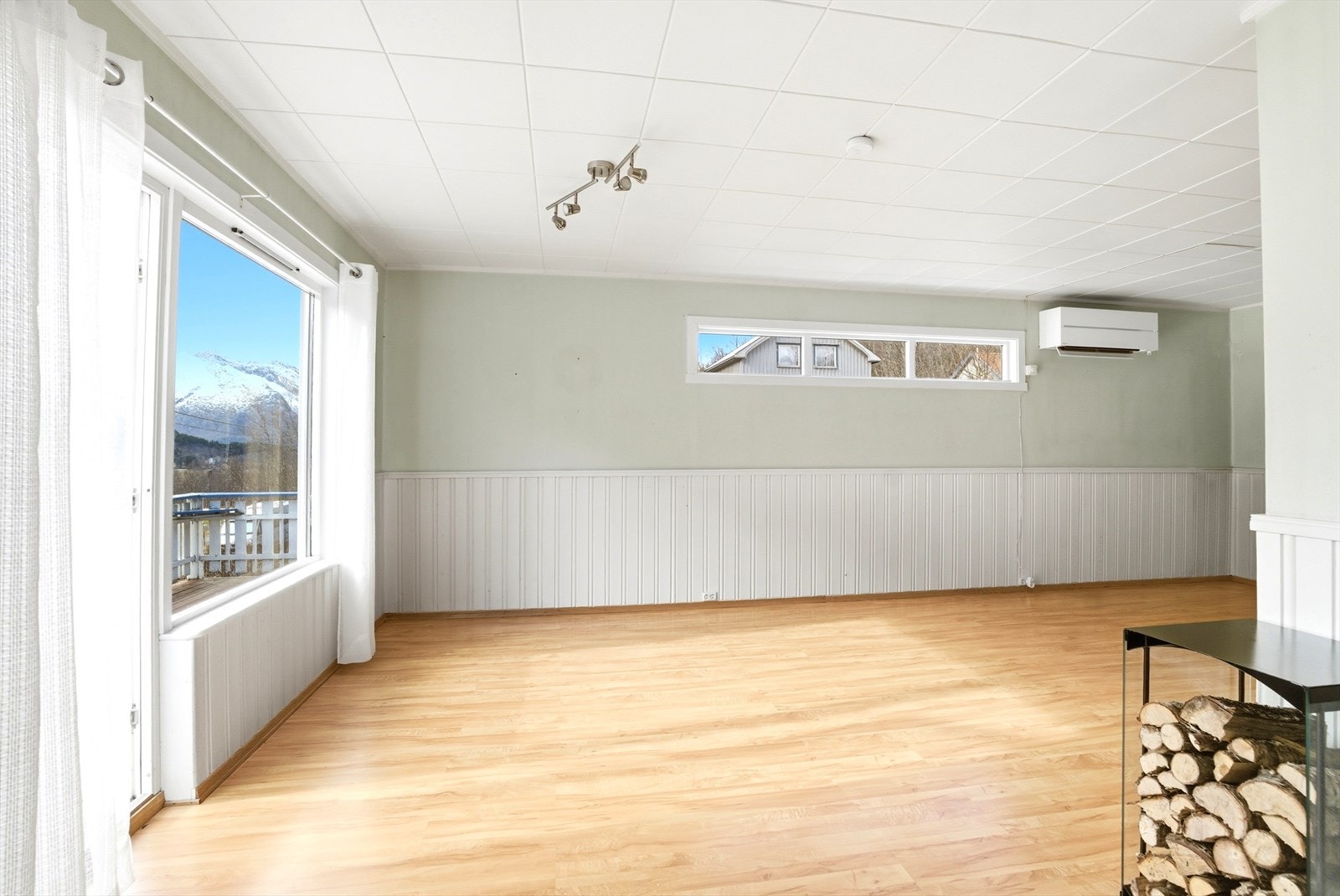 Romslig stue med stort vindu som slipper inn dagslys. Galleribilde