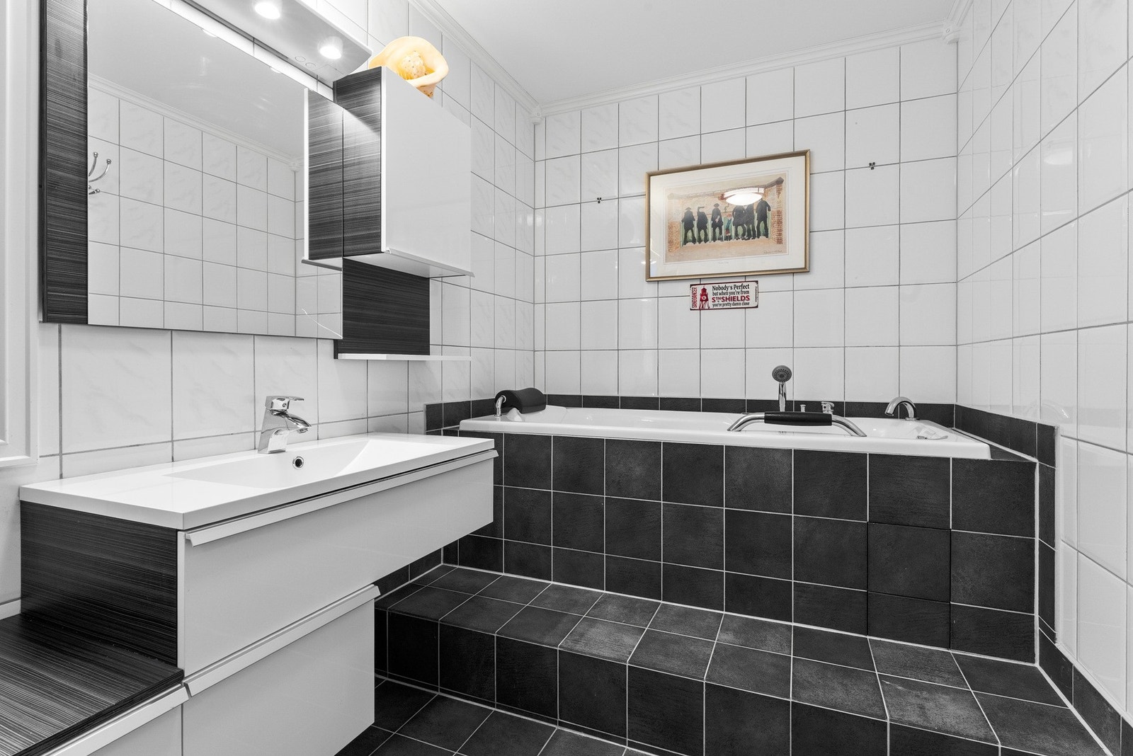 Baderommet har et elegant innfliset boblebadekar og varmekabler i gulvet for ekstra komfort Galleribilde