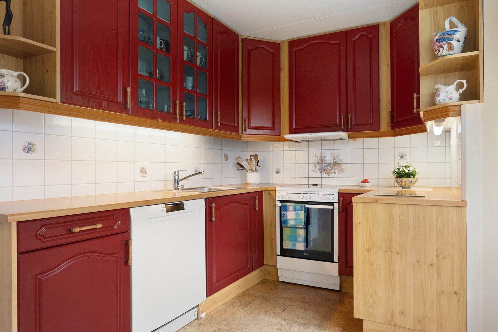 Kjøkken innredning fra 1996, innredet med profilerte fronter og benkeplate i laminat. Frittstående komfyr, oppvaskmaskin, kjøl- og fryseskap. Galleribilde