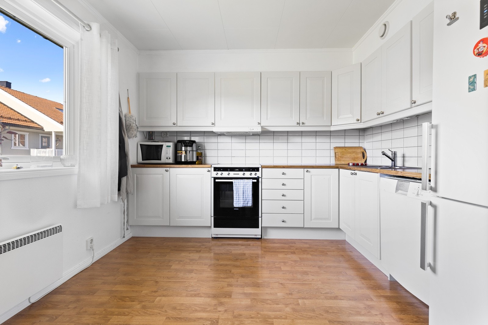 Innredning med profilerte fronter med foring opp til tak og laminert benkeplate med nedfelt vaskekum i rustfritt stål. Det er satt inn fliser mellom over- og underskap, samt downlights i himling. Galleribilde