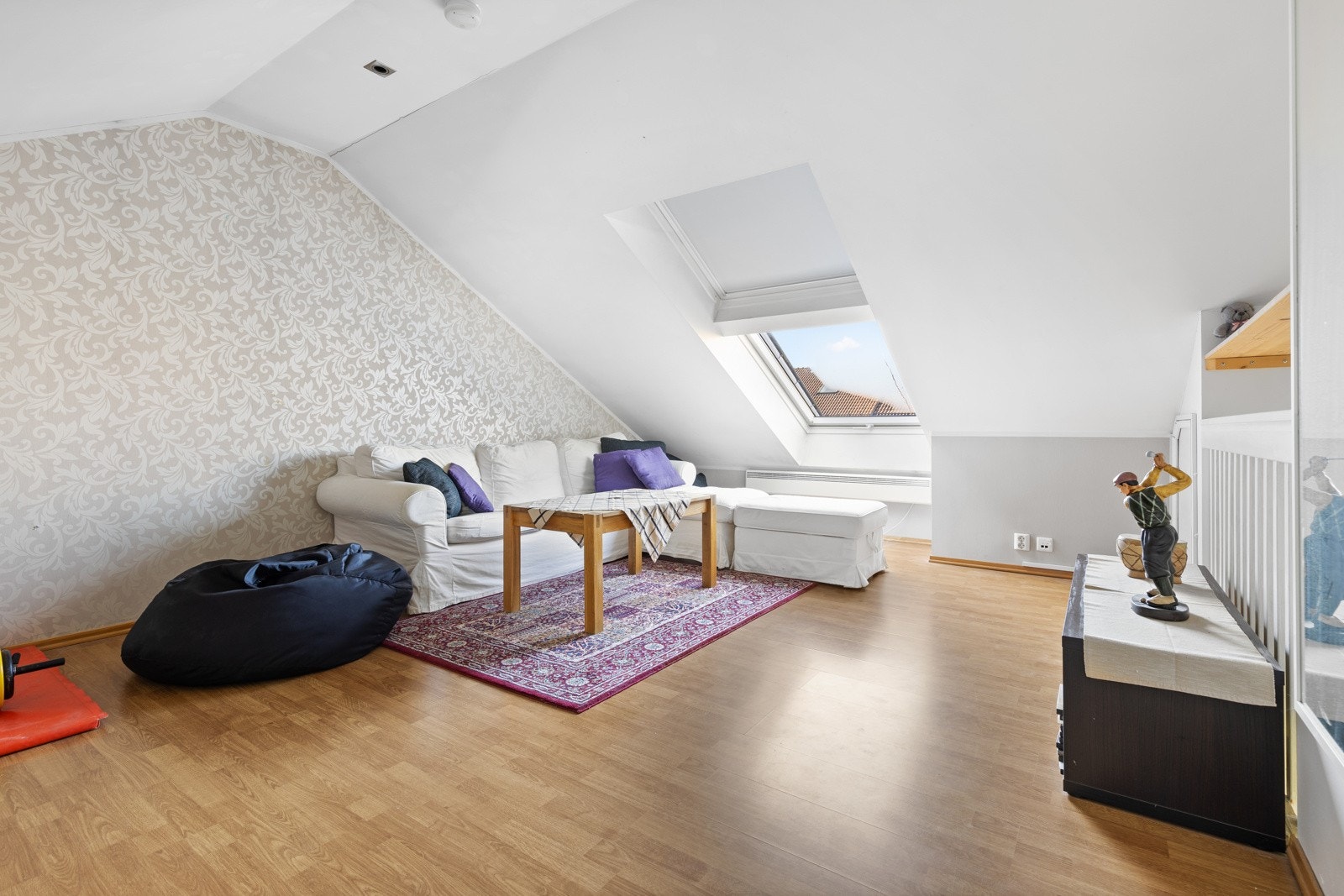 Tiltalende loftstue med sjarmerende skråtak og skylight vindu i himlingen. Rommet har god plass til sofa og Tv-løsning, noe som gir ekstra spillerom og privatliv hos familier. Galleribilde