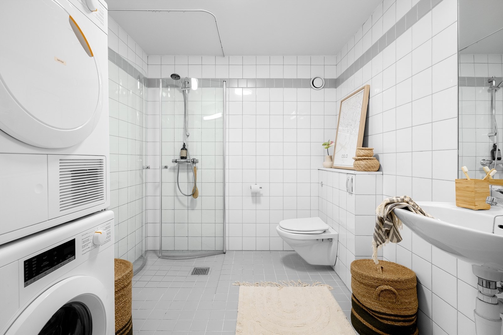 Badet er innredet med servant, toalett, dusjhjørne, samt opplegg for vaskemaskin og tørketrommel. Galleribilde