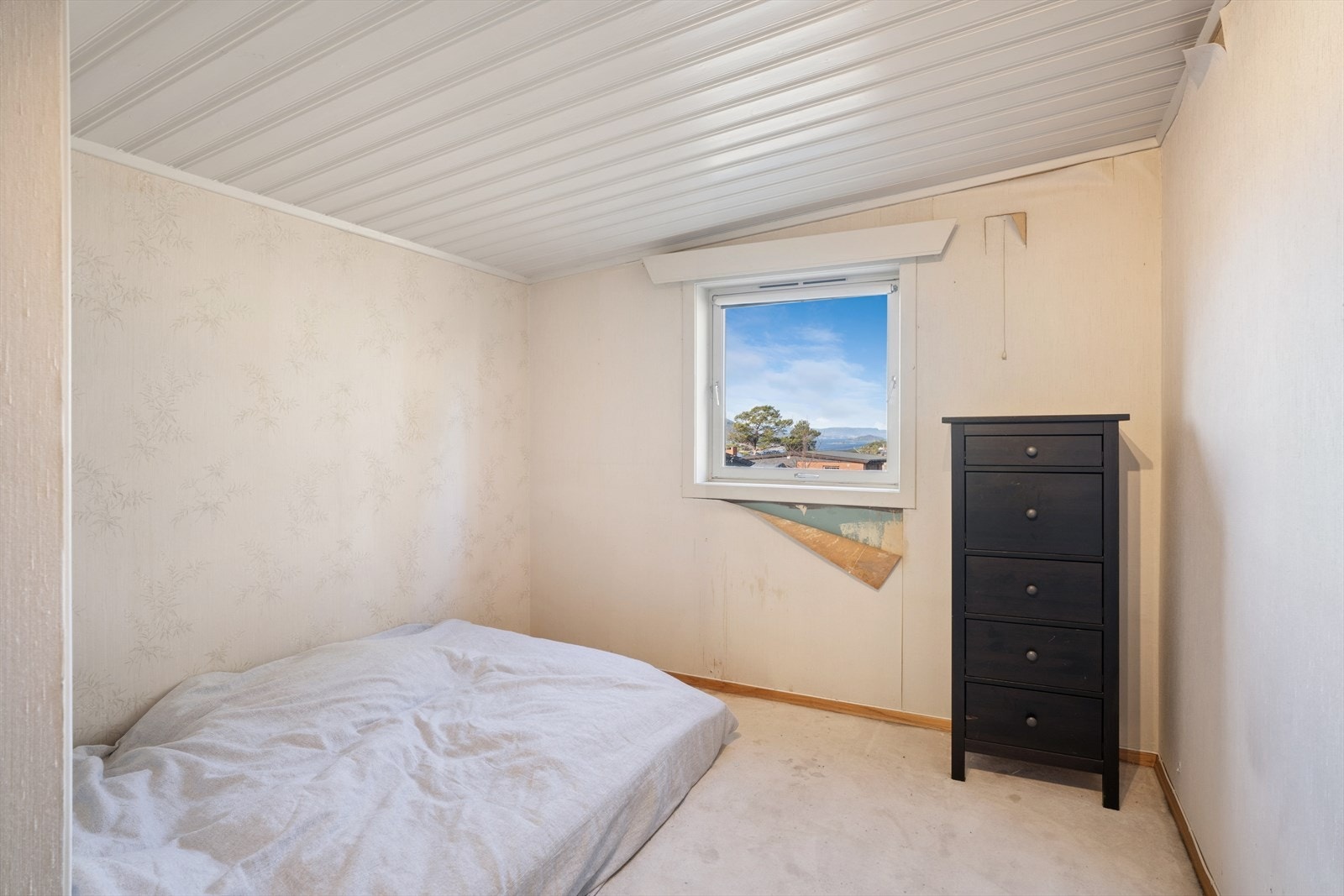 Soverom i boligens 1. etasje. Her er det teppe på gulvet og panel i himling. Galleribilde