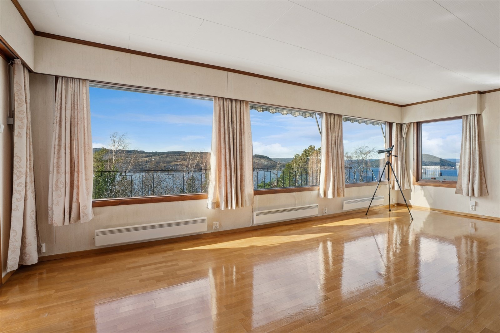 Husets hjerte er den romslige stuen med god plass til hele familien. Her er det klassisk parkett på gulvet, tapet på veggene og malte himlingsplater. Galleribilde