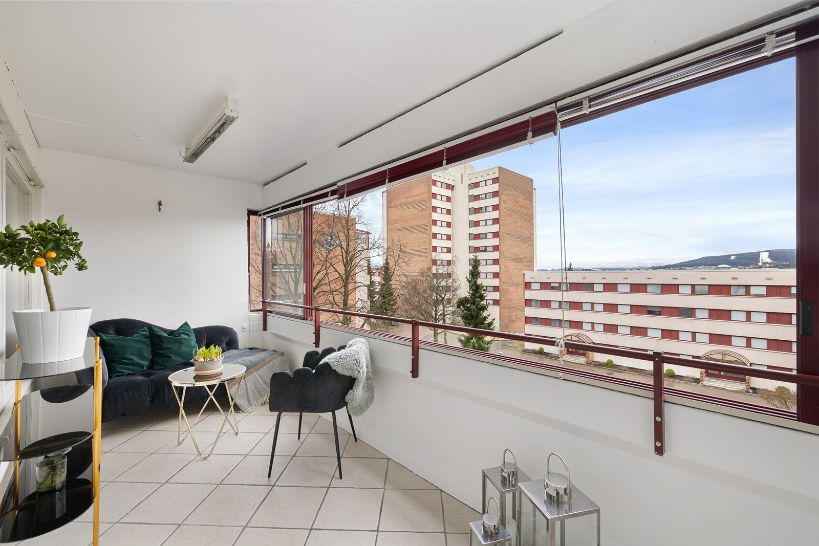 Stor balkong med innglassing og god plass til både sittegruppe og annet møblement, som oppleves som en forlengelse av stuen Galleribilde