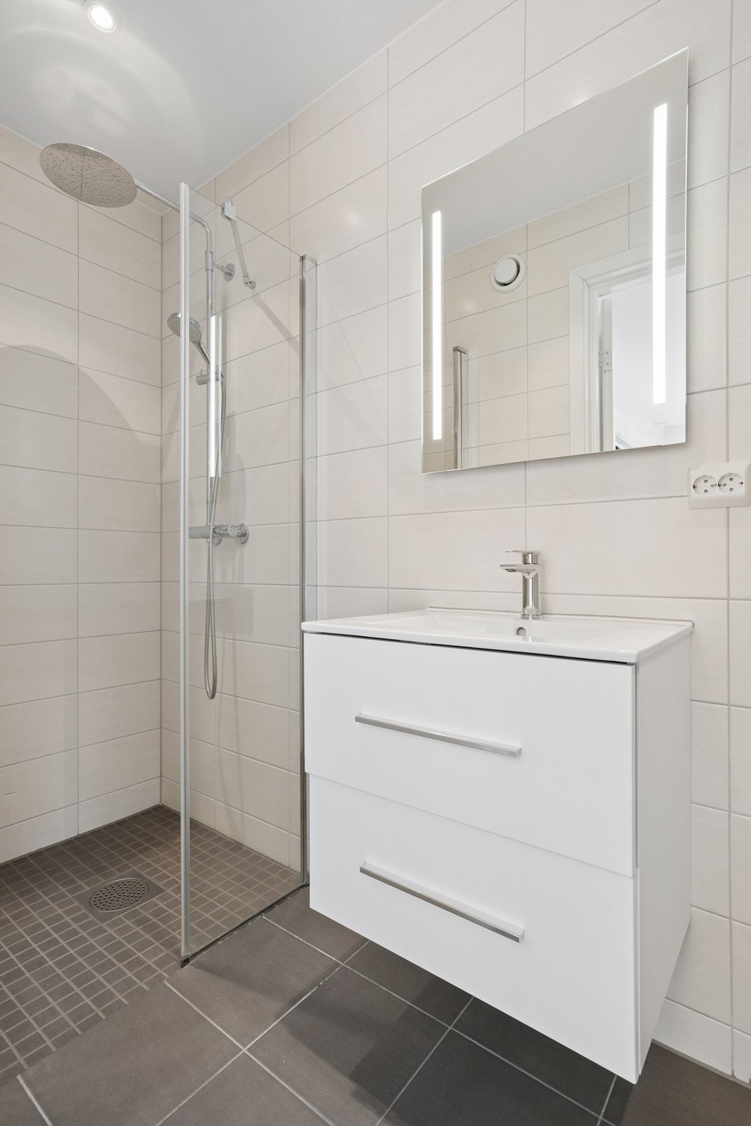 Badet er helfliset og har termostatstyrt gulvvarme og downlights. Galleribilde
