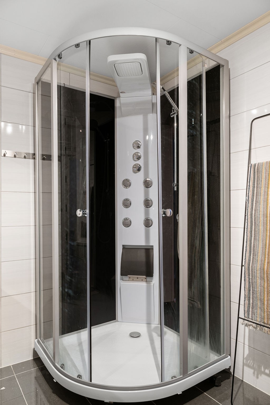 Badet har vegghengt toalett, dusj, servant i seksjon samt høyskap med god oppbevaringsplass. Galleribilde