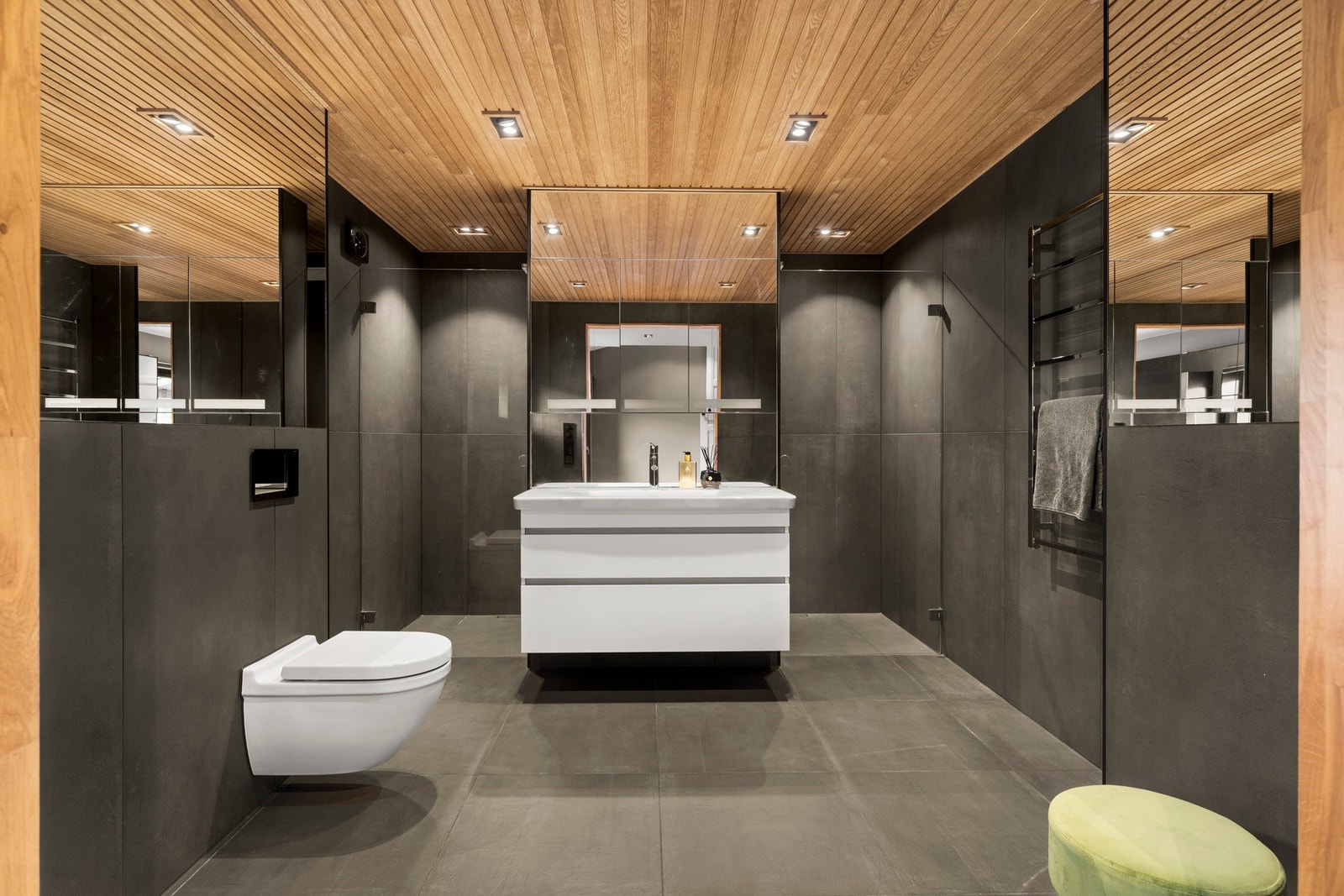 Badet fremstår moderne og delikat med flislagte overflater og varmekabler i gulv Galleribilde