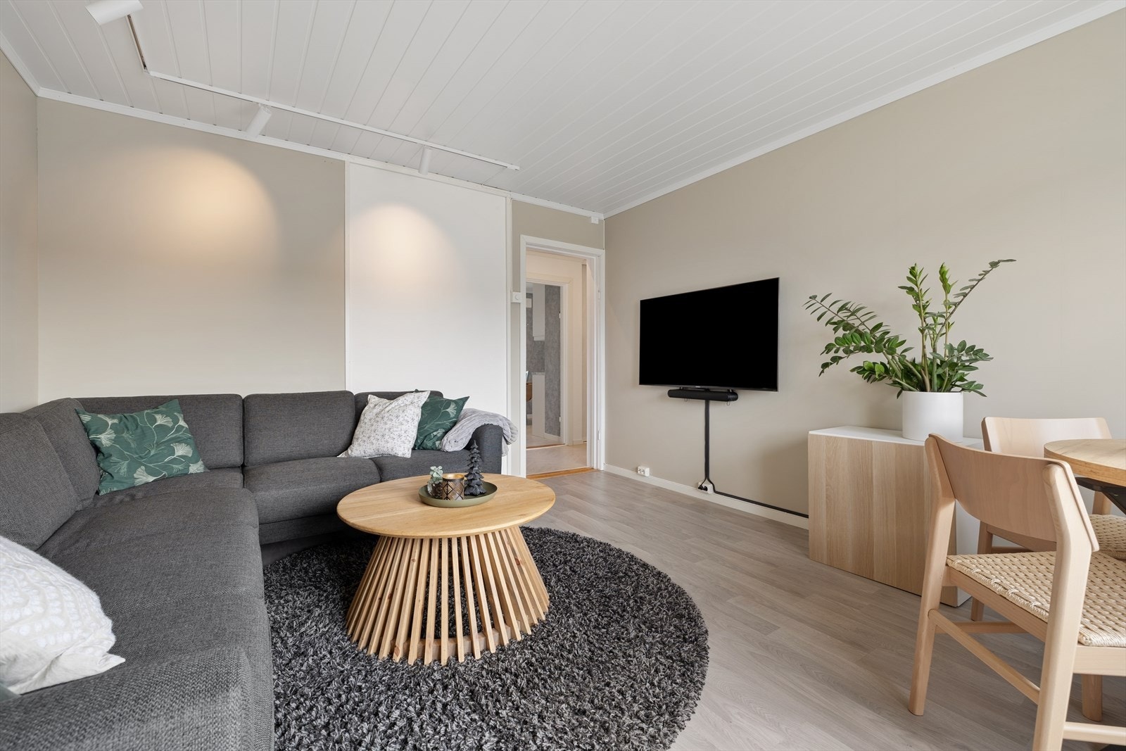 Stuen fremstår lun og innbydende, med tidsriktig fargevalg og en naturlig sone for både sofa og TV. Galleribilde