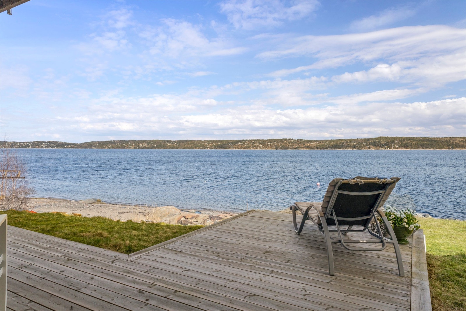 Utsikt over vannet fra terrasse med tilgang til strand. Galleribilde