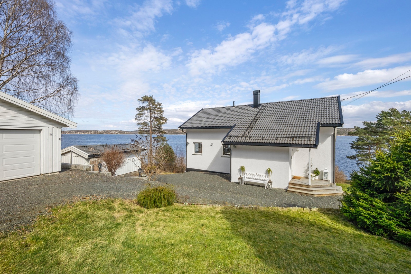 Hvit enebolig med garasje og utsikt mot vannet. Galleribilde