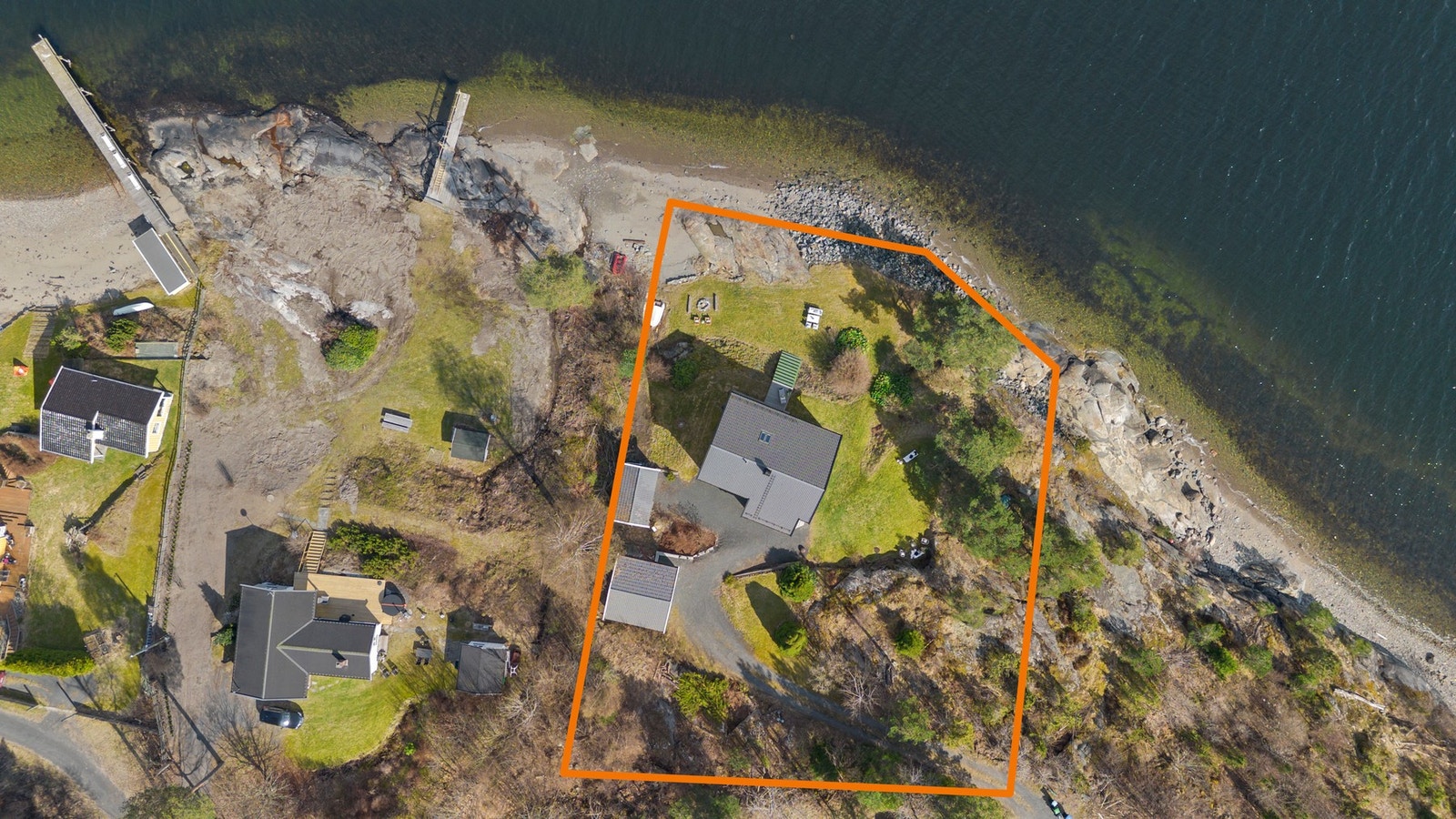 Luftfoto av eiendom ved sjøen med markert tomtegrense. Galleribilde