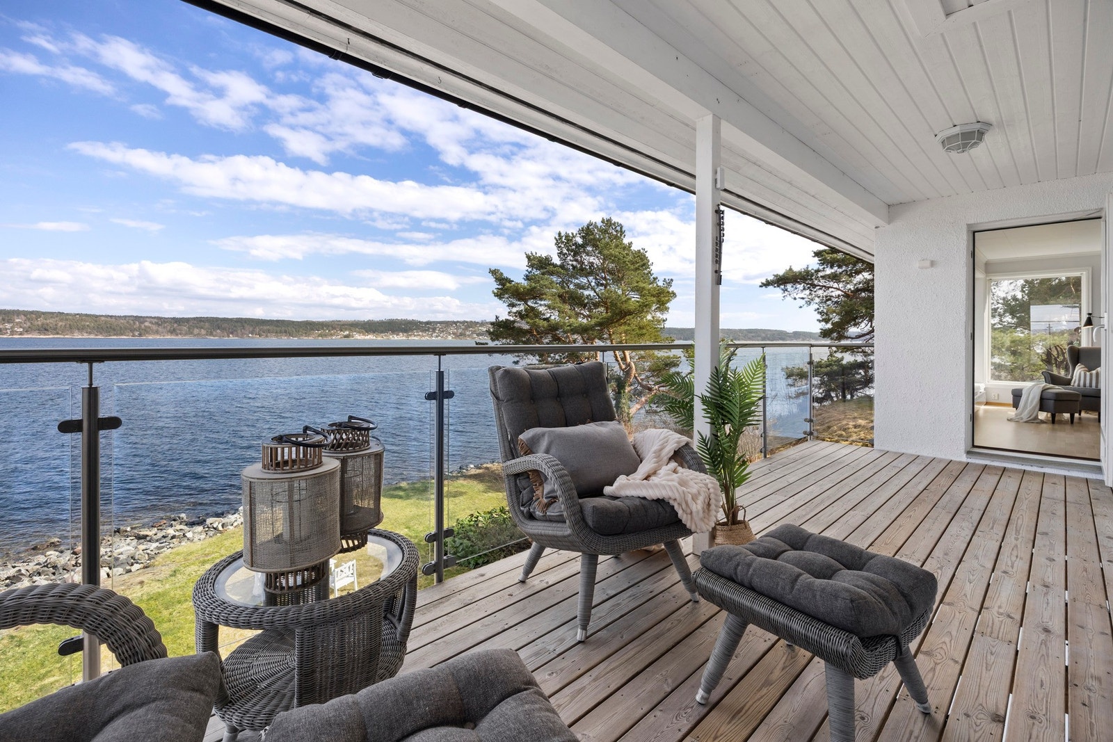 Stor terrasse med utsikt over vannet og nærliggende skogsområde. Galleribilde