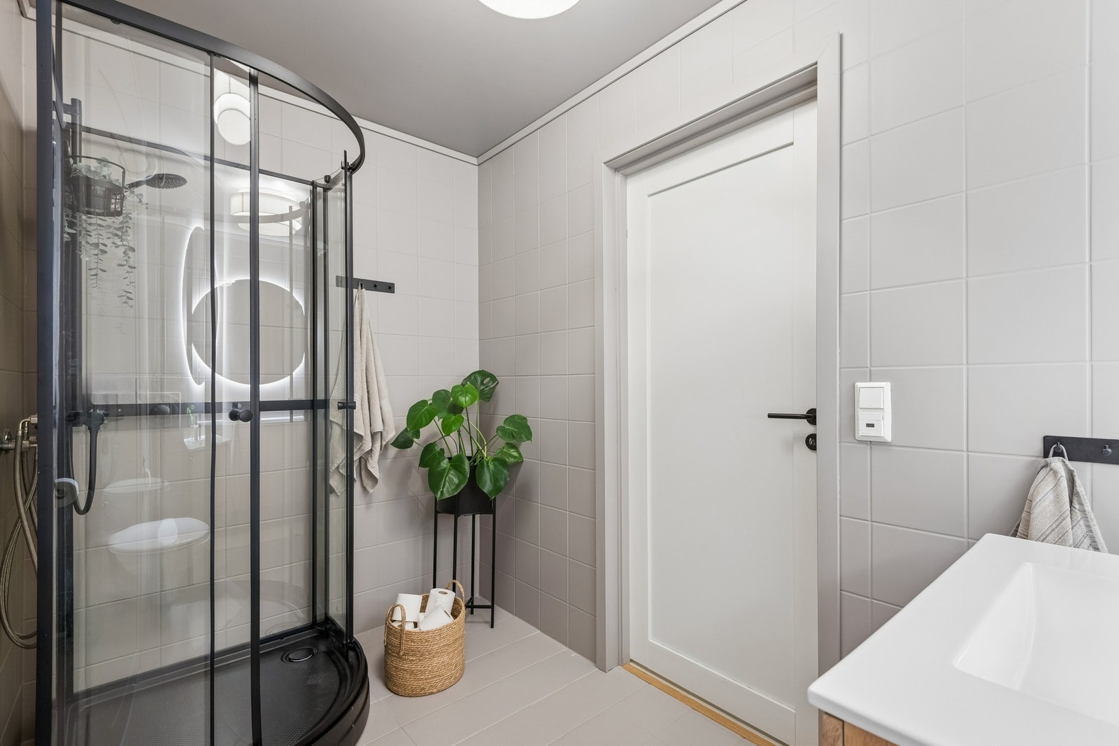 Badet har dusjkabinett med sorte detaljer. Galleribilde