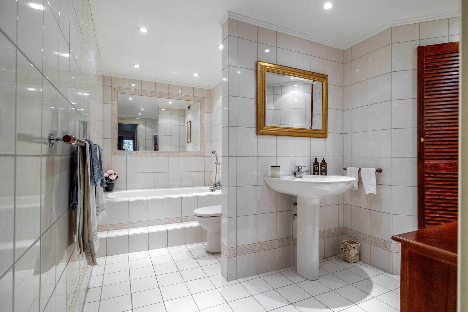 Bad 1 - Stort baderom, i tilknytning til hoved soverommet. Badet inneholder bl.a. servant, speil, toalett og dusj-løsning med innmurt badekar. Downlights i tak og varmekabler i gulv. Galleribilde