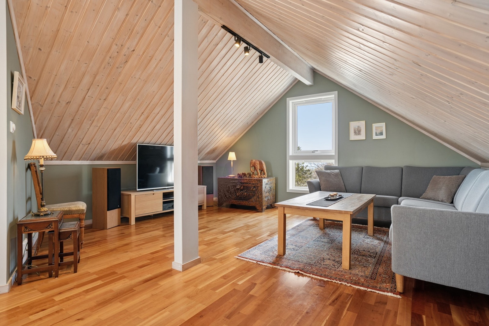 Parkett på gulv og panel i taket skaper en lun og koselig atmosfære. Loft innredet som tv-stue, opprinnelig byggegodkjent som disponibelt rom. Rommet er ikke omsøkt. Galleribilde