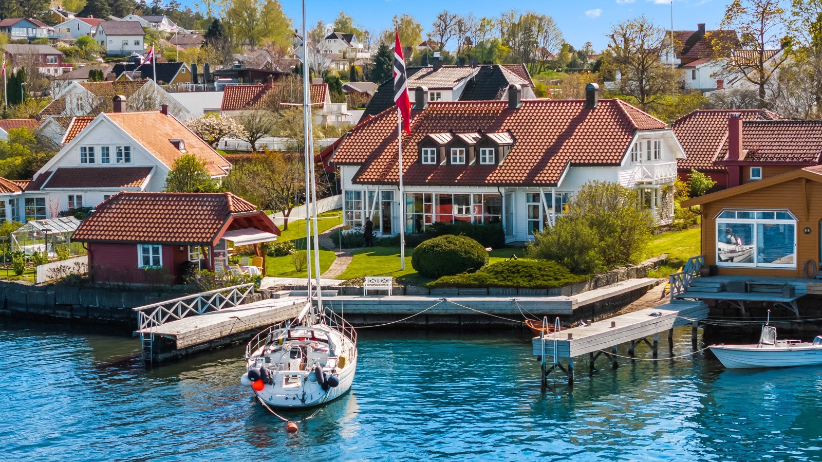 Eiendom med sjølinje, bryggeanlegg, sjøbod og sandstrand Galleribilde