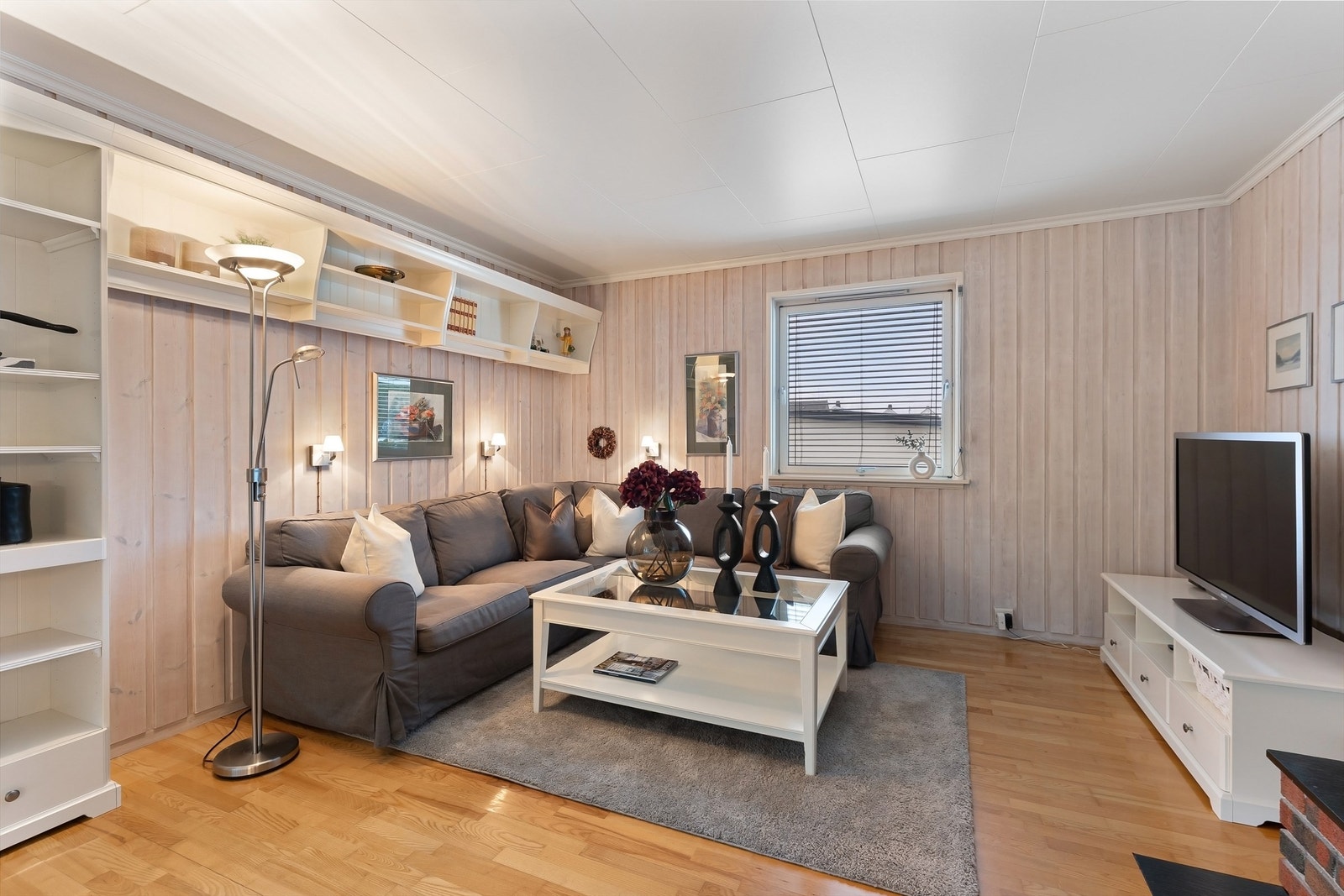 Plassbygde hyller gir smart oppbevaring og en fin ramme rundt sofakroken. Galleribilde