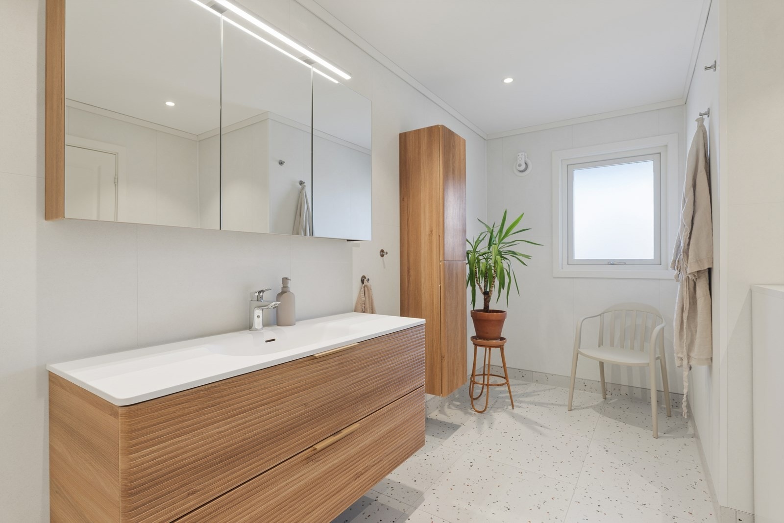 Badet byr på moderne innredning med frittstående toalett, dusjsone med glassvegger og praktisk opplegg for vaskemaskin, samt nytt vindu som gir godt dagslys. Galleribilde