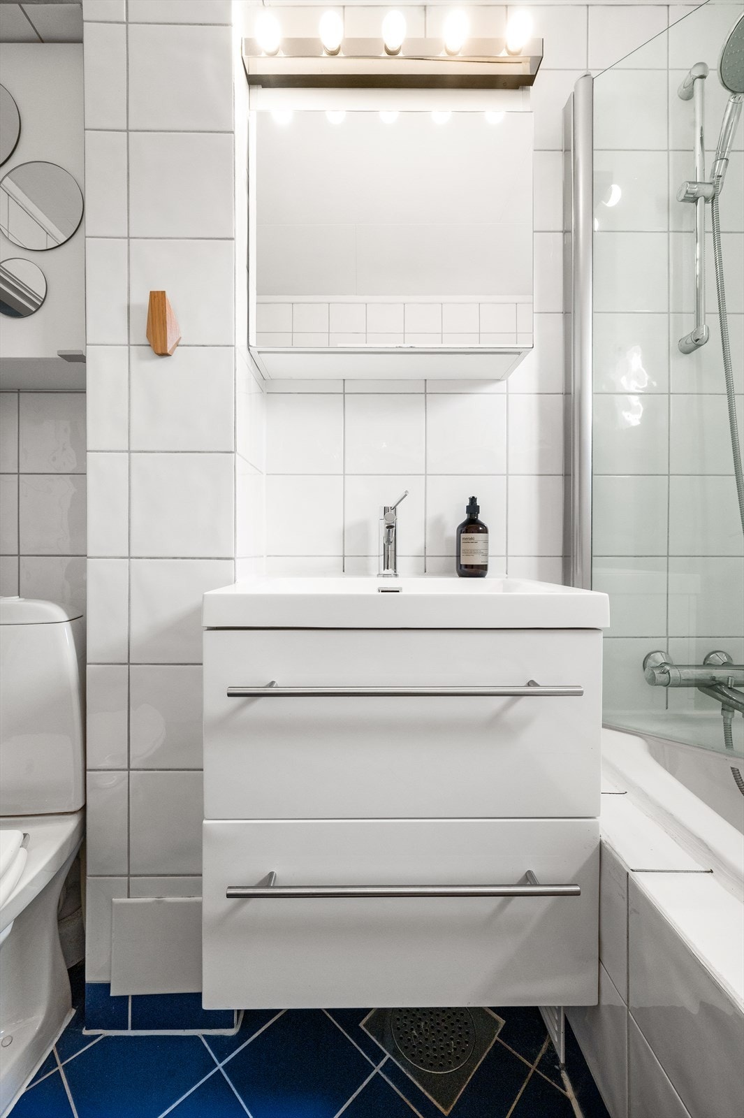 Badet er også utstyrt med gulvstående klosett, vegghengt servantinnredning og speilskap med belysning. Galleribilde