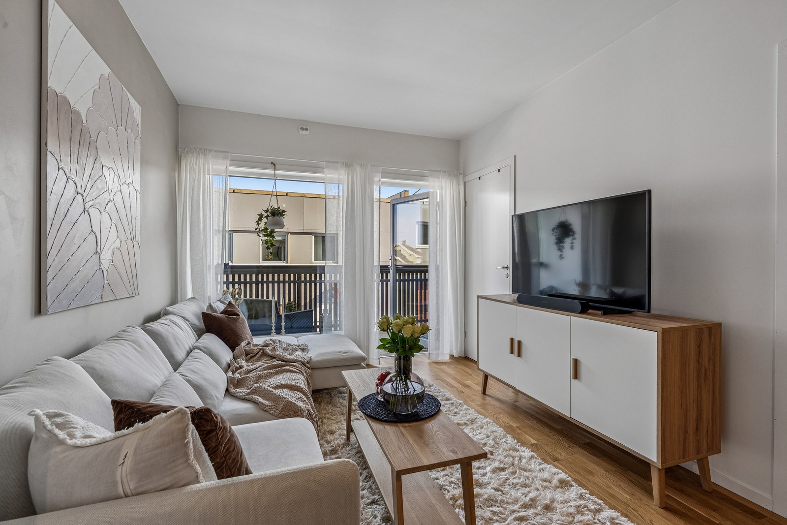 Innbydende stue med moderne preg og utgang til balkong. Galleribilde