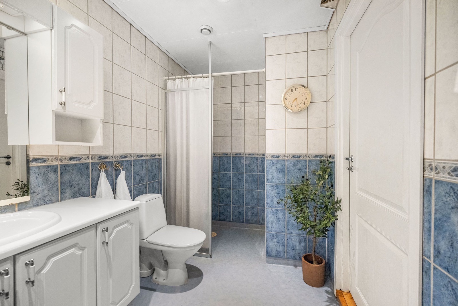 Badet er innredet med vegghengt servantskap med nedfelt servant, speil med overlys, dusjnisje og toalett. Galleribilde